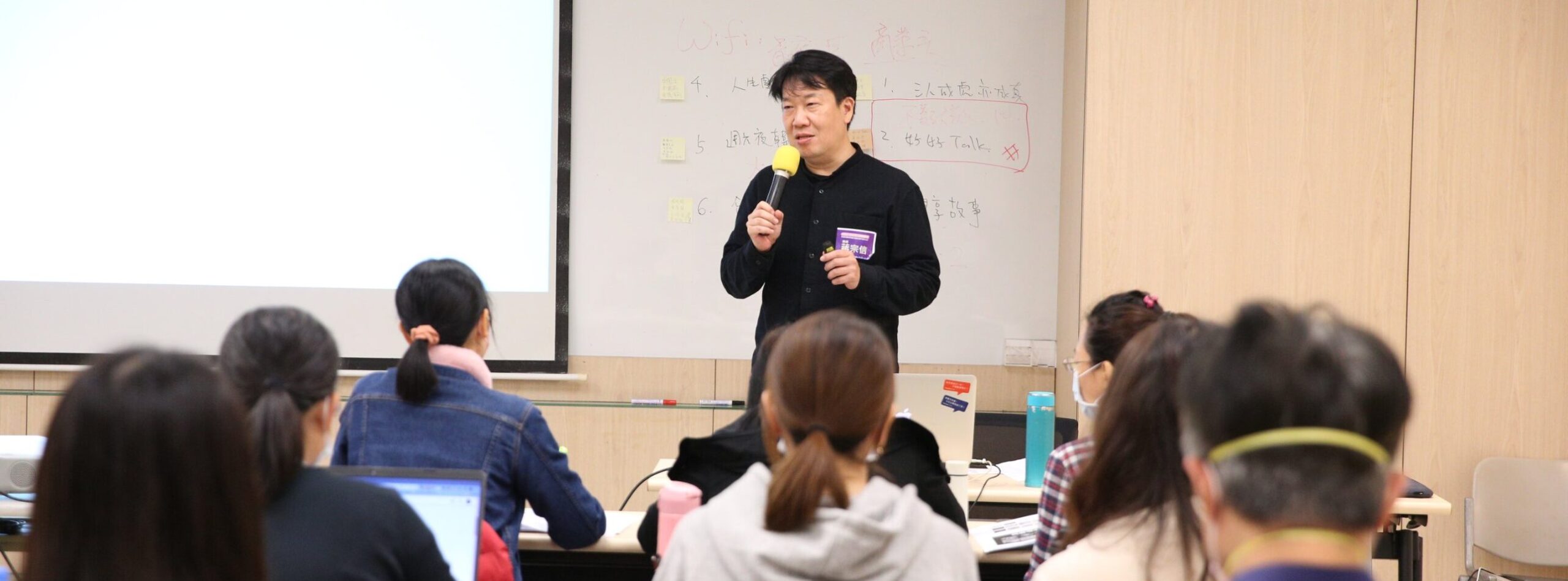 Vito大叔拿著麥克風在教室為學員講課