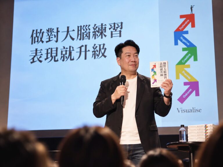 Vito大叔在講台上手持《做對大腦練習，表現就升級》分享視覺化練習