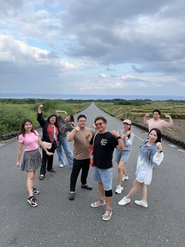 一群好朋友在台東長濱金剛大道上比出強壯姿勢合照